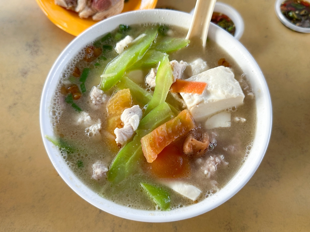 For a more refreshing take on pork noodles, their bittergourd pork noodles has tender bitter gourd slices, cut tomatoes and soft beancurd, while the broth has a dash of Shao Xing wine. — Picture by Lee Khang Yi 