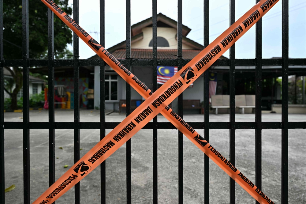 Social Welfare Department tape blocks off a gate at the entrance to a care home after a crackdown by authorities in Subang Jaya September 12, 2024. — AFP pic