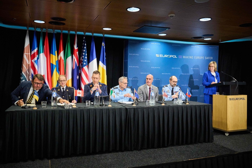 Europol Executive Director Catherine De Bolle (right) addresses a press conference next to members of an international coalition of law enforcement representatives to announce the results of a major operation against the encrypted communications platform 'Ghost', which is used for criminal activities, in The Hague on September 18, 2024. — AFP pic