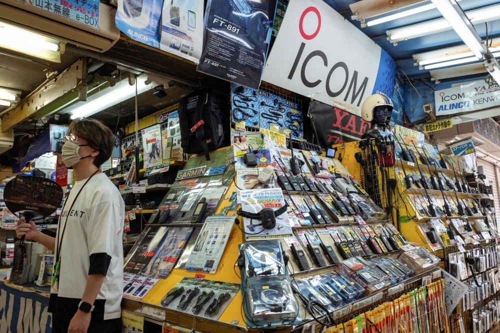 A sign with the logo of Japanese walkie-talkie maker Icom (centre top) is displayed at a shop that specialises in wireless devices in Tokyo's Akihabara electric district on September 19, 2024. — AFP pic