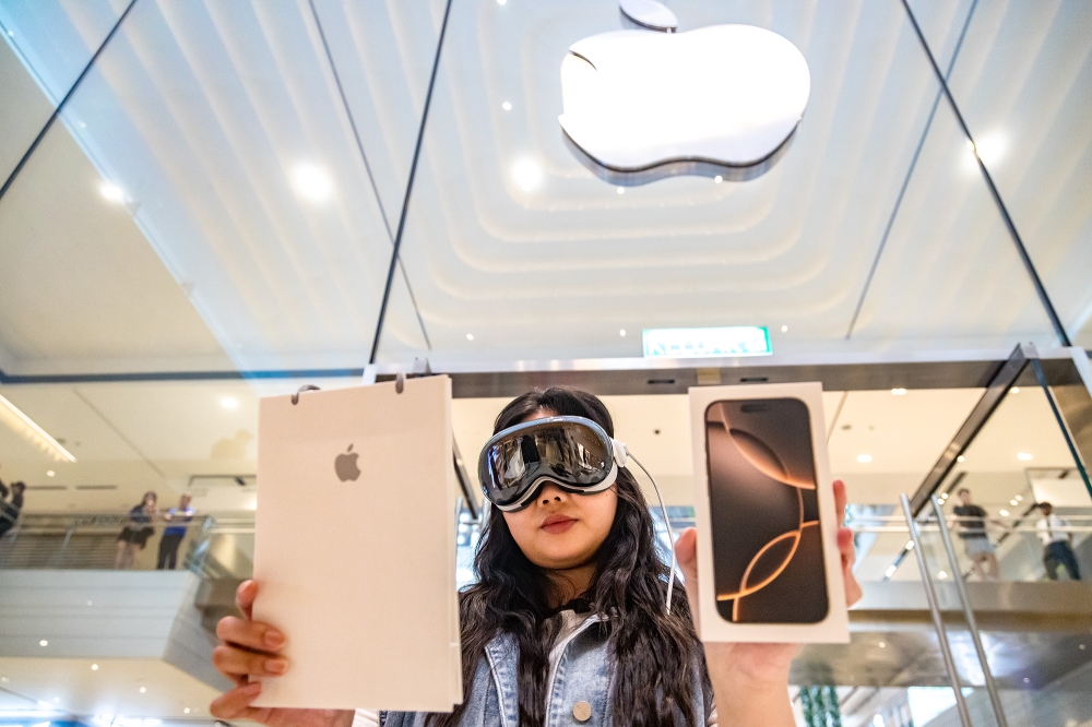 Jena, 25 poses with her new iPhone 16 during launch day at the Apple store at Tun Razak Exchange (TRX) in Kuala Lumpur, September 20, 2024. — Picture by Firdaus Latif