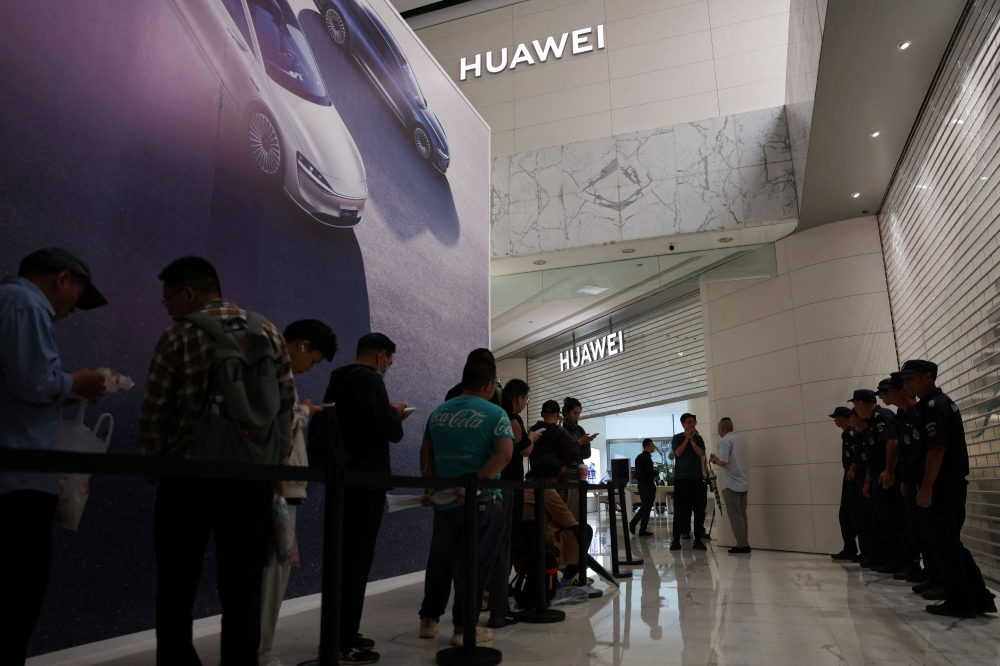 People queue outside a Huawei flagship store ahead of its opening hours, before the Huawei Mate XT tri-foldable smartphone goes on sale in Beijing September 20, 2024. — Reuters pic  