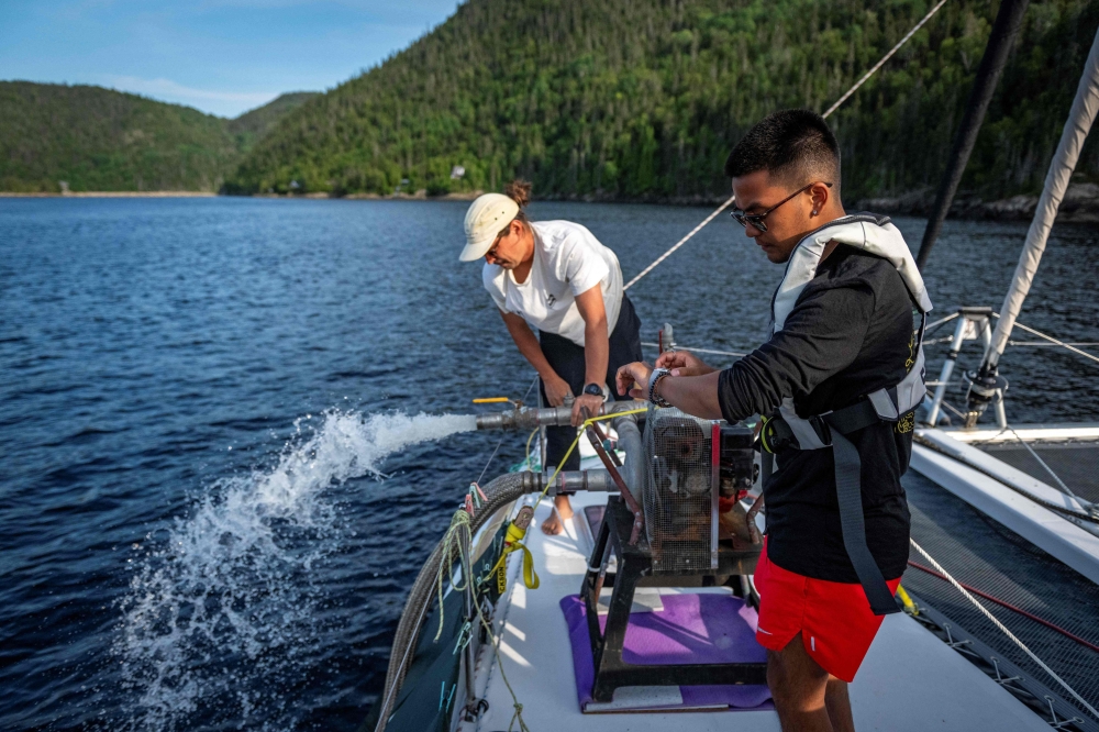 Adrien Bernier, Captain of the Catamaran Vanamo and Miguel Felismino, PhD Engineer at McGill University, at work during the Blue Expedition, in Petit-Saguenay, Quebec July 24, 2024. — AFP pic