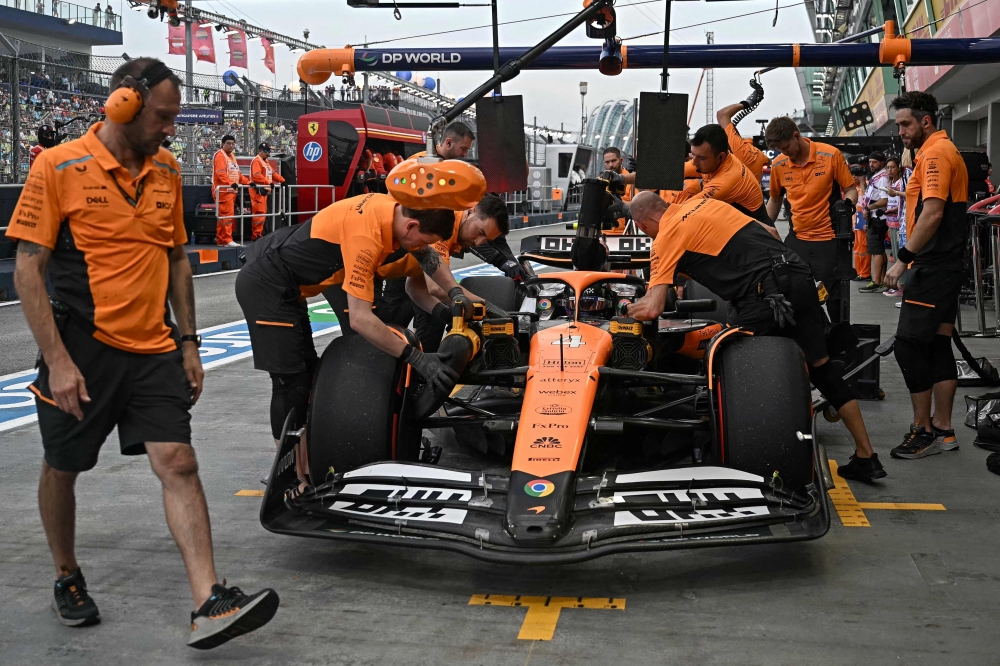 Team mechanics work on the car of McLaren's British driver Lando Norris during the first practice session ahead of the Formula One Singapore Grand Prix night race at the Marina Bay Street Circuit in Singapore on September 20, 2024. — AFP pic