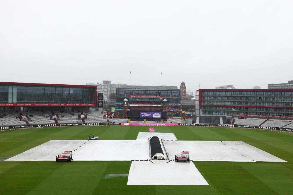 Rain covers protect the ground as the 3rd 'Vitality IT20' Twenty20 International cricket match between England and Australia is delayed at Old Trafford, in Manchester, on September 15, 2024. — AFP pic