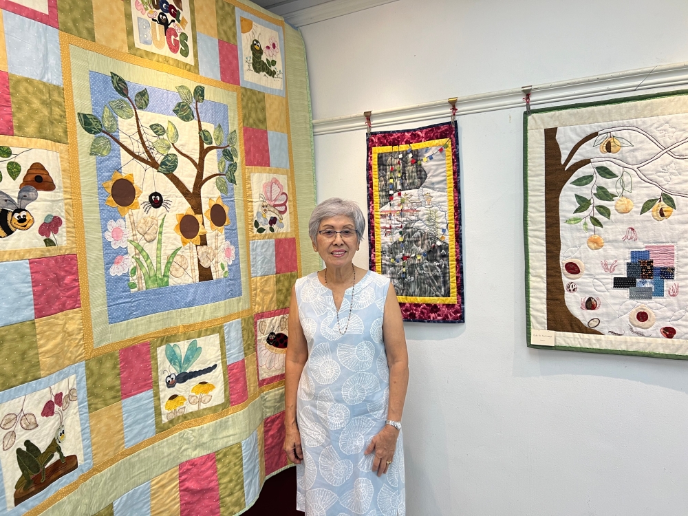 Janie Yap with a quilt she made for her granddaughter’s 12th birthday. Behind her is the quilt that was inspired by her trek up the Tiger’s Nest in Bhutan and the quilt on the right, the nutmegs. — Picture by Opalyn Mok