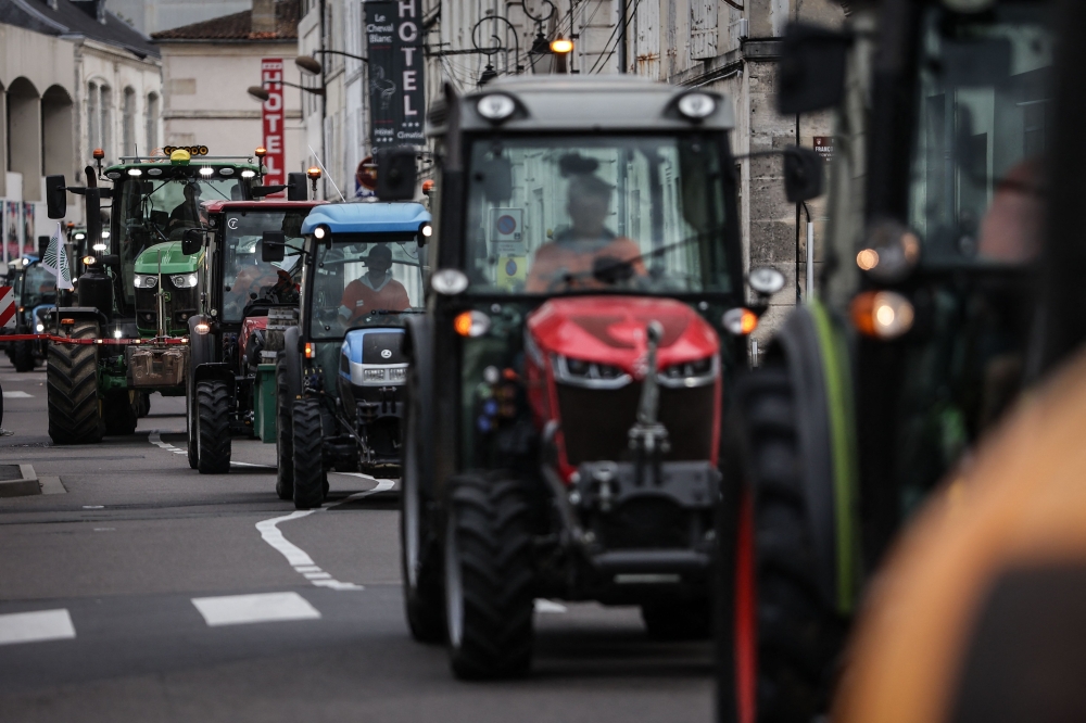 Cognac winegrowers drive tractors during a demonstration against Chinese tax threats, in Cognac September 17, 2024. Some 800 protestors riding on tractors and carrying signs gathered in France's southwestern town of Cognac on September 17, 2024, demanding a delay to an upcoming European Union vote to impose duties on Chinese electric vehicles. — AFP pic