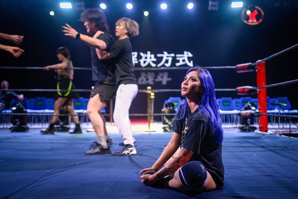 This picture taken on September 14, 2024 shows Filipina wrestler ‘Crystal’ looking on as she sits on the ring's floor during a rehearsal for a Middle Kingdom Wrestling (MKW) championship event in Shanghai. — AFP pic