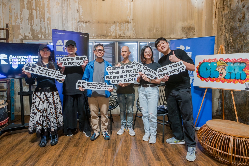 AR Fest KL founder Fariz Hanapiah (centre) with street art artists and AR artists who contributed towards reimagining murals for the inaugural festival. — Picture by Raymond Manuel