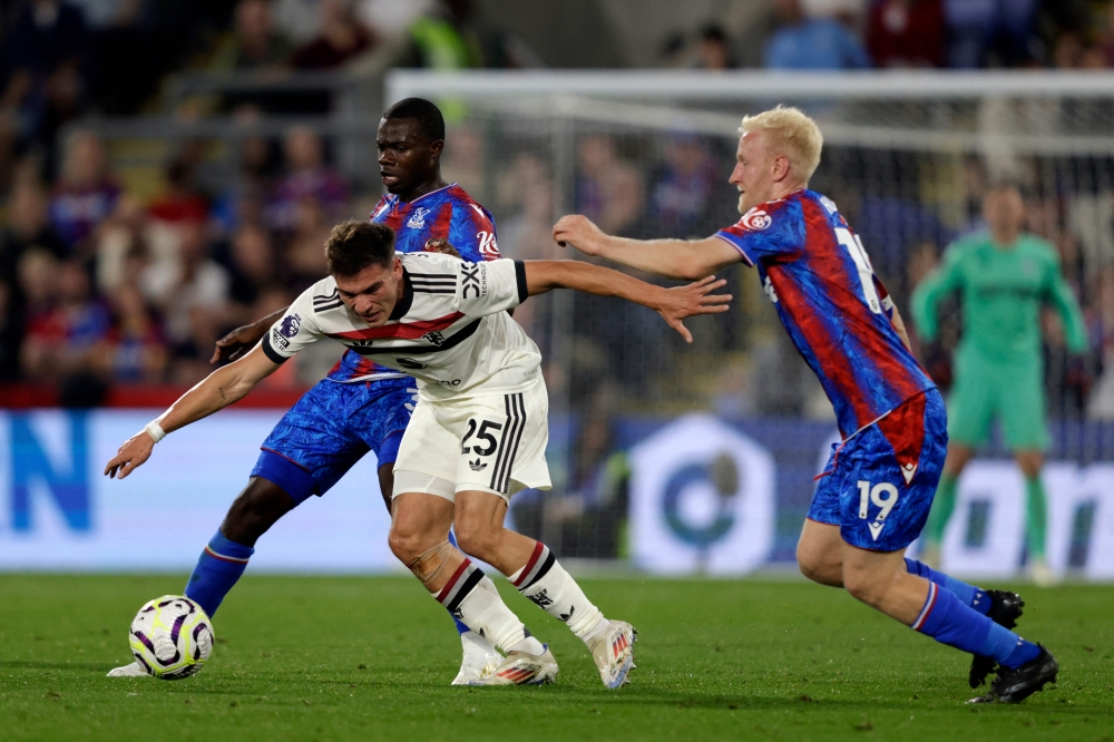 Manchester United's Uruguayan midfielder #25 Manuel Ugarte (centre) vies with Crystal Palace's English defender #03 Tyrick Mitchell (left) and Crystal Palace's English midfielder #19 Will Hughes (right) during the English Premier League football match between Crystal Palace and Manchester United at Selhurst Park in south London September 21, 2024. — AFP pic