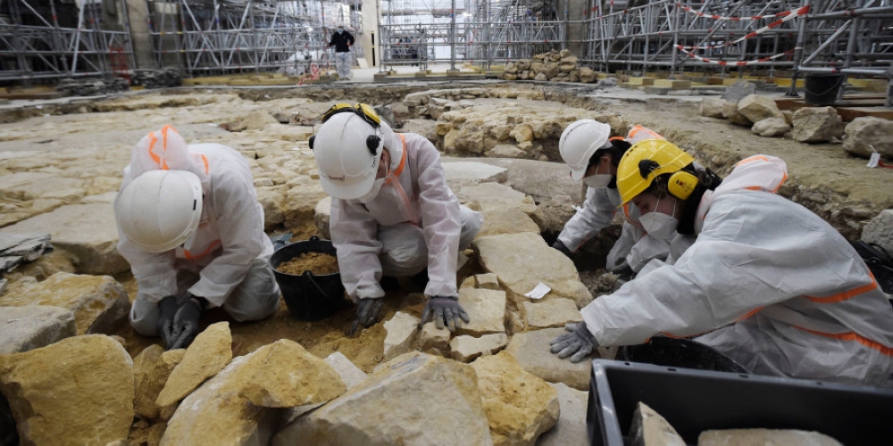 Archaeologists excavate the floor of the Notre-Dame Cathedral after the discovery of a 16th century lead sarcophagus in Paris. — AFP pic