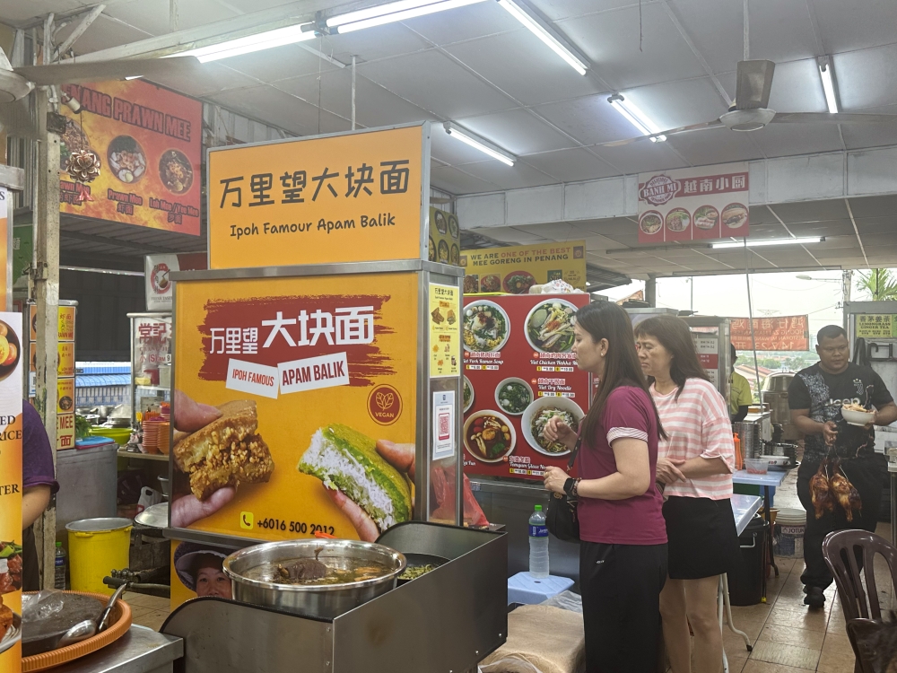 The stall is in the middle of the corner lot and many queue to pack the 'apam balik' home.  — Picture by Lee Khang Yi