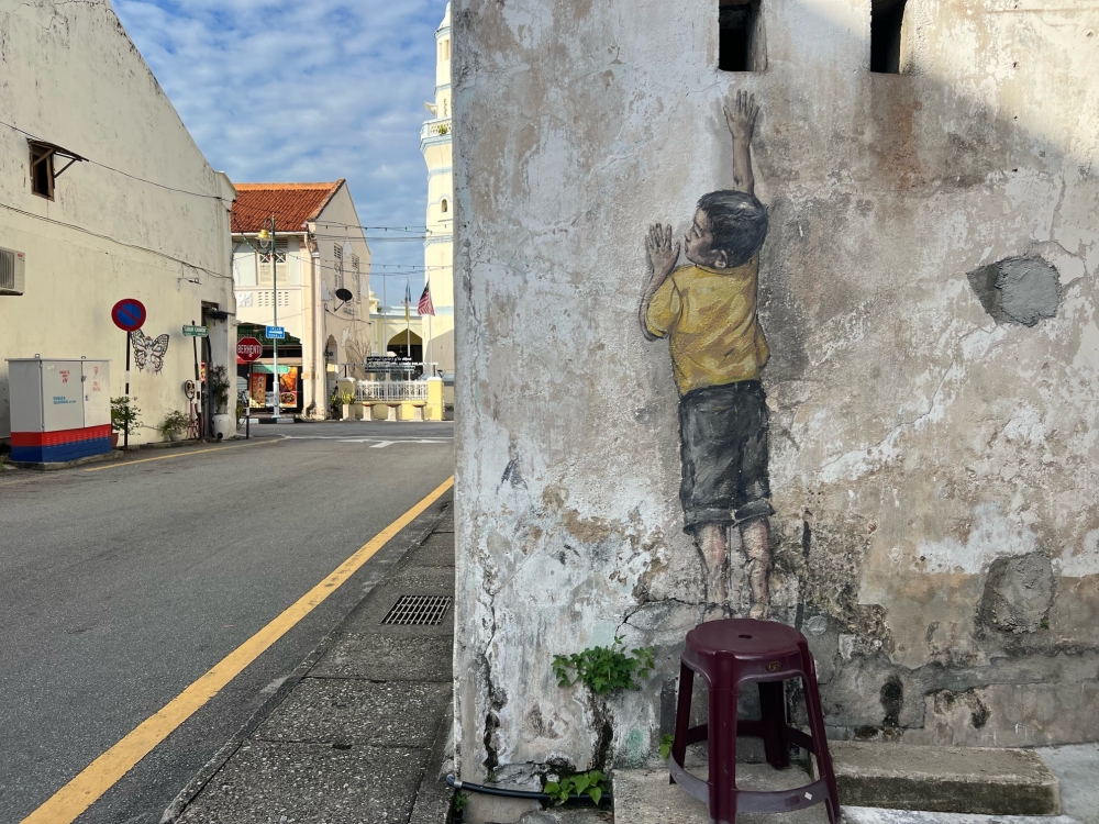 The 'Boy on Chair' artwork at Cannon Street will take around a week to restore. — Picture by Opalyn Mok