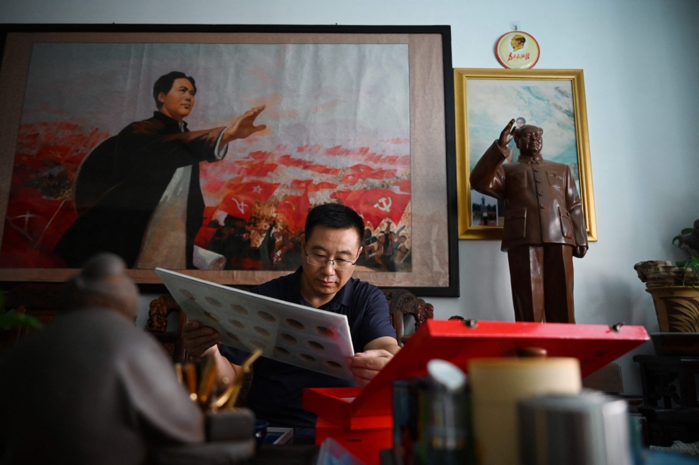 Former soldier and Mao memorabilia collector Feng Gang looks at his displays of pins featuring the image of late Chinese communist leader Mao Zedong in his living room in Baotou September 7, 2024. — AFP pic