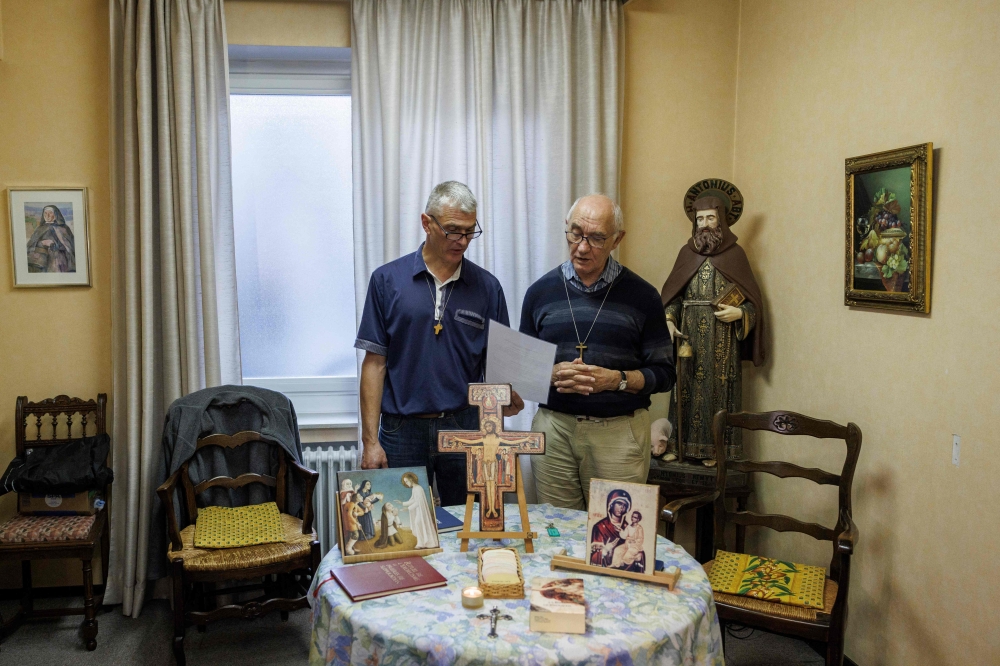 Thierry Moser, priest of the ‘Trois Vignes’ parish and deacon Jacques Beckand speak in a room used by priests to conduct exorcism sessions at the Home Saint Joseph in Brussels September 11, 2024. — AFP pic