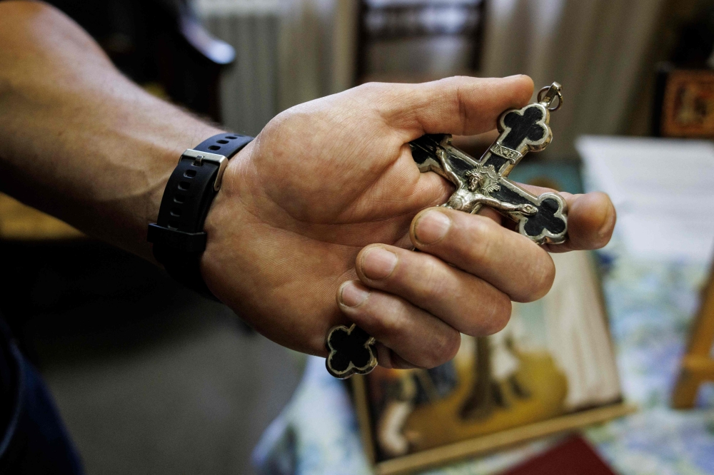 Thierry Moser, priest of the ‘Trois Vignes’ parish, holds a crucifix in a room used by priests to conduct exorcism sessions at the Home Saint Joseph in Brussels September 11, 2024. — AFP pic