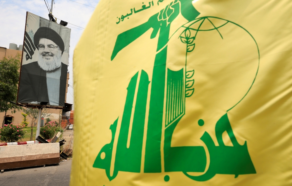 A Hezbollah flag and a poster depicting Lebanon’s Hezbollah leader Sayyed Hassan Nasrallah are pictured along a street, near Sidon, Lebanon July 7, 2020. — Reuters pic