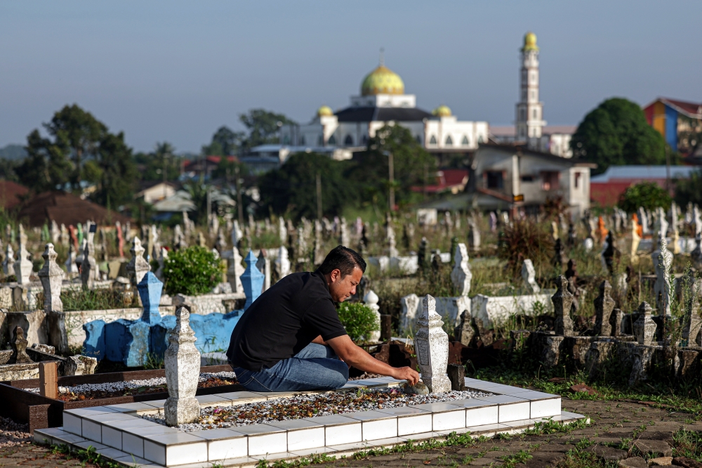 Newly elected Mahkota assemblyman Syed Hussien Syed Abdullah, spends a quiet moment at grave of his father Syed Abdullah Syed Abdul Hamid who died and was buried at the Kampung Melayu Muslim Cemetery in Kluang, Johor four days prior to the start of the by-election. — Bernama pic