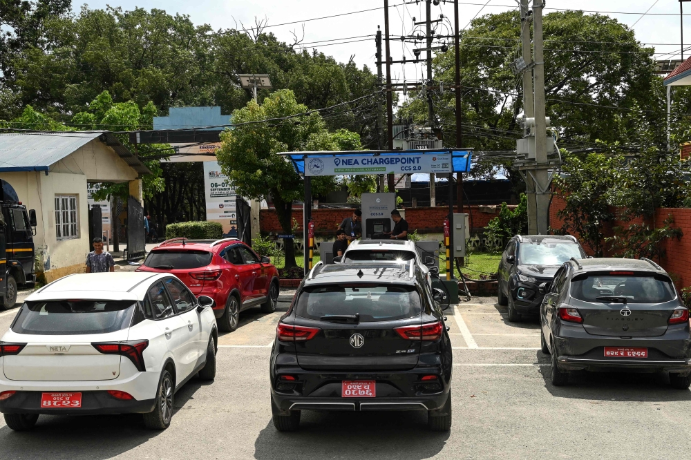 In this photograph taken on September 5, 2024, people charge their electric vehicles (EVs) at a charging station in Kathmandu. — AFP pic