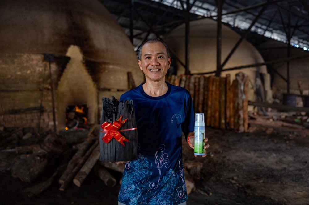 Charcoal factory operator Chuah Kee Yong, 53, holds products made from mangrove wood charcoal. — Bernama pic