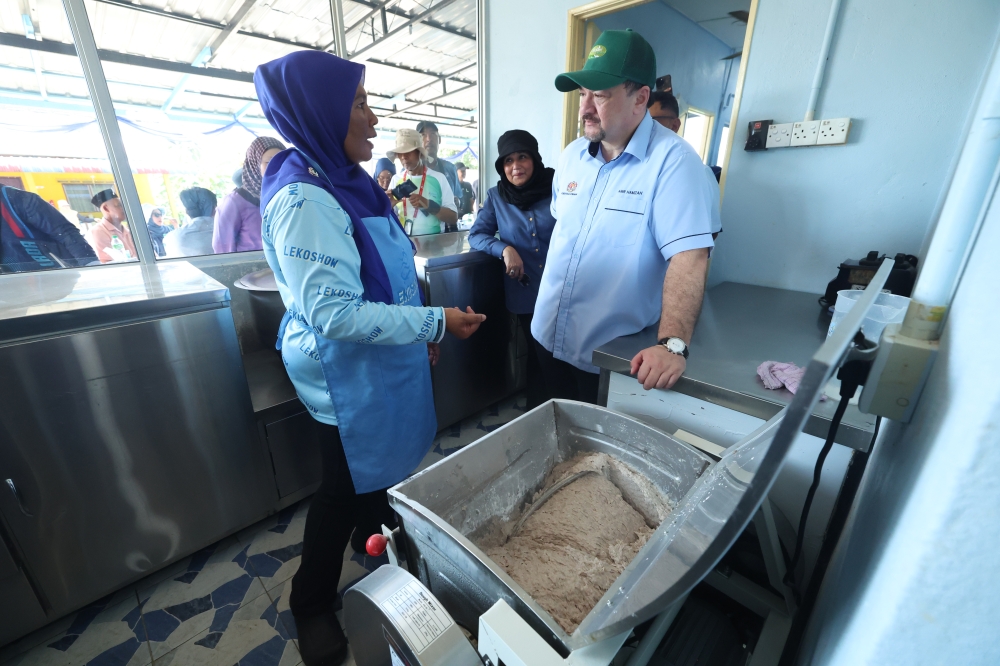 Finance Minister II Datuk Seri Amir Hamzah Azizan chats with keropok lekor entrepreneur Rosnani Che Ghazali during his visit to Pulau Tuba in Langkawi September 28, 2024. — Bernama pic