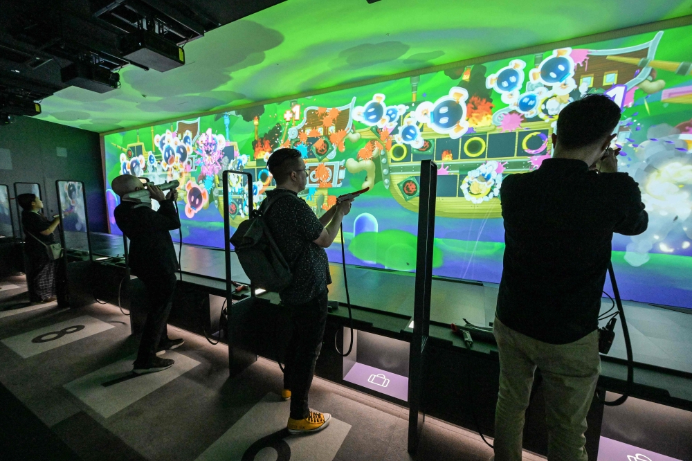 This photo taken on September 24, 2024 shows visitors playing the shooting game ‘Zapper and Scope SP’ during a media preview of the new Nintendo Museum, located inside a renovated old factory, in suburbs of Kyoto. — AFP pic