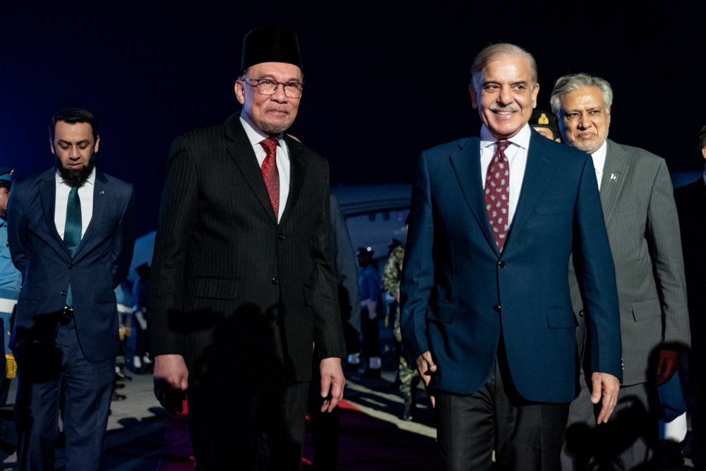 Prime Minister Datuk Seri Anwar Ibrahim with this Pakistani counterpart Shehbaz Sharif upon his arrival at Pakistan Air Force’s Nur Khan Airbase in Rawalpindi last night. — Picture from X/Anwar Ibrahim 