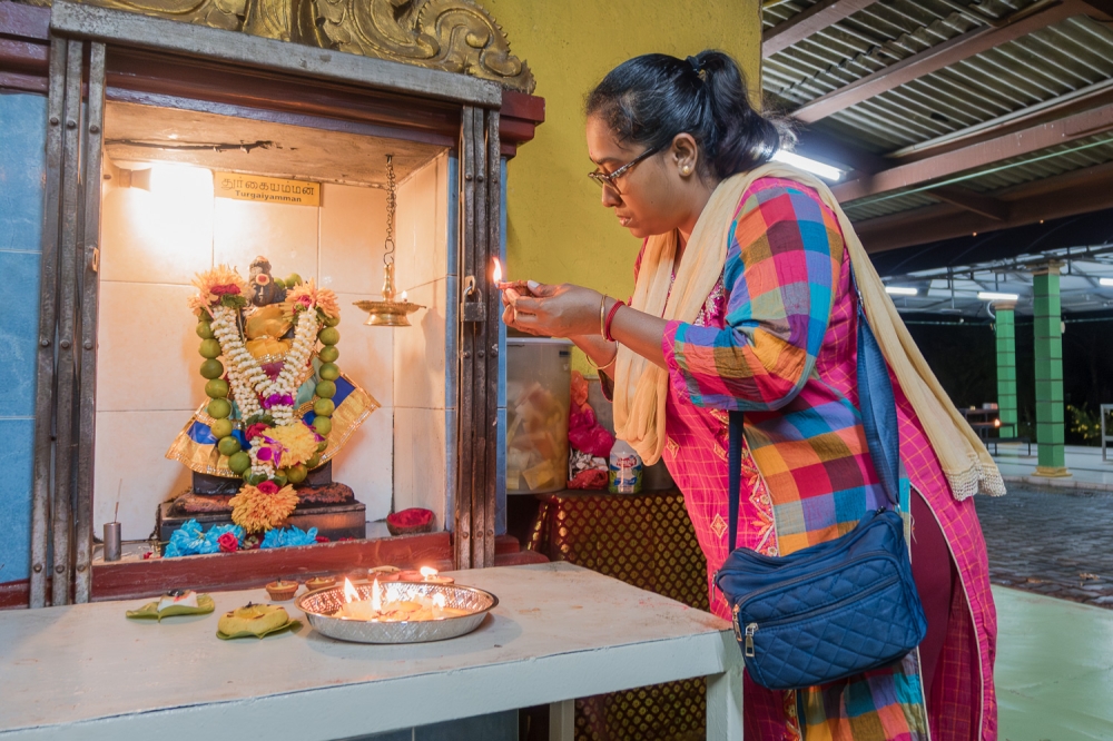 A Hindu devotee lights a lamp during Navaratri celebrations at a temple in Semenyih, Selangor on October 3, 2024. — Picture By Raymond Manuel