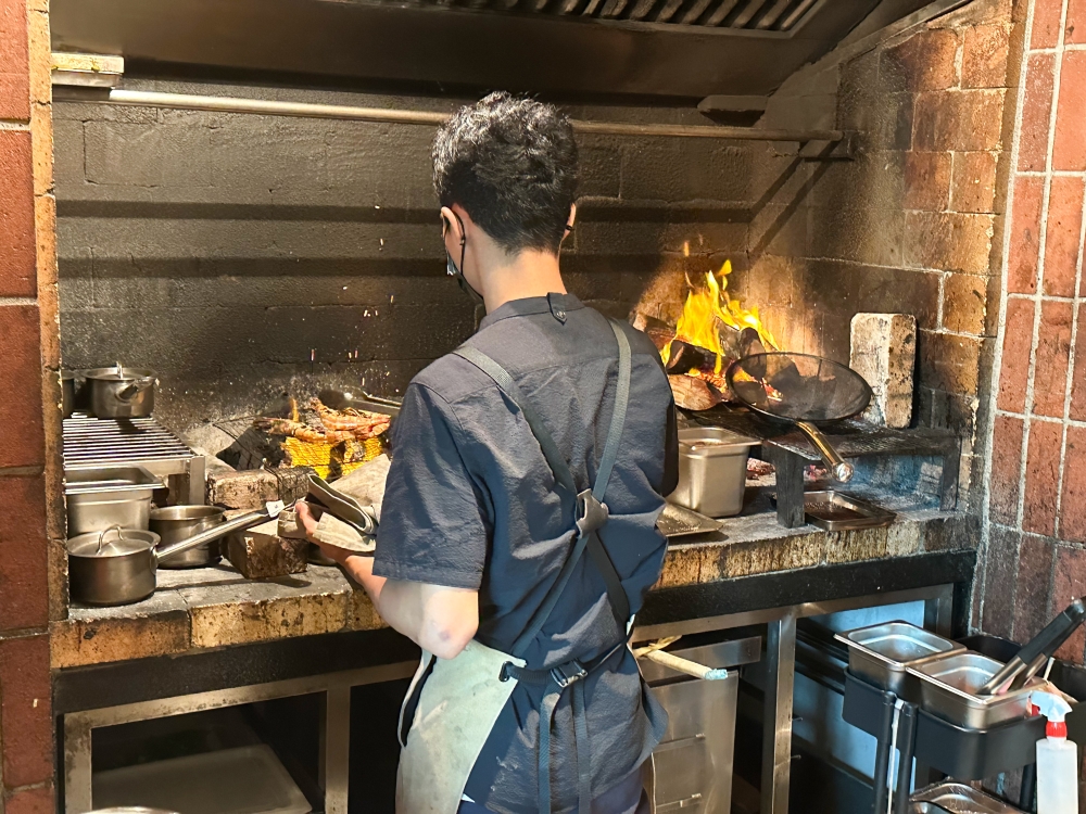 Cooking with fire requires a chill demeanour as one focuses on what's cooking on the hot grill — Picture by Lee Khang Yi