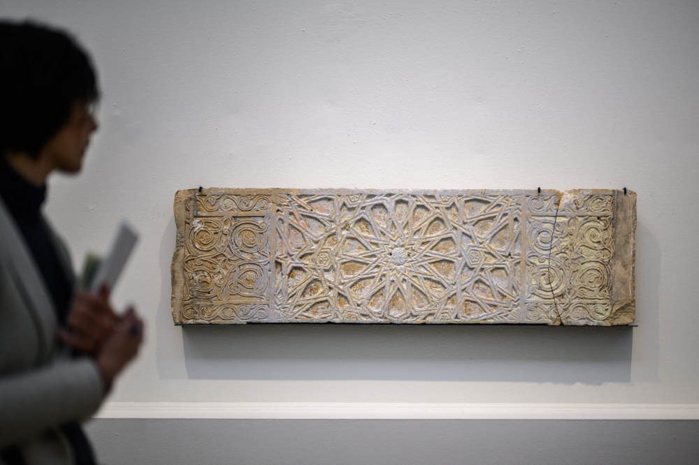 A visitor walks past a lintel in two fragments (Mamluk period, 13th-15th century) discovered in 1995 in the Zeytoun district in Gaza City, during an exhibition on protection of cultural property in case of conflict entitled ‘Heritage in Peril’ at the Art and History Museum in Geneva October 3, 2024. — AFP pic