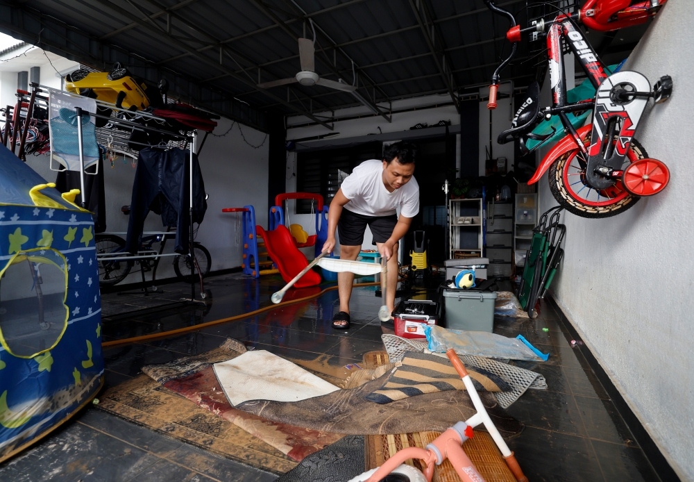 A resident cleans his house after flash floods hit in Taman Saujana Aman, Kuala Selangor on October 4, 2024. — Bernama pic