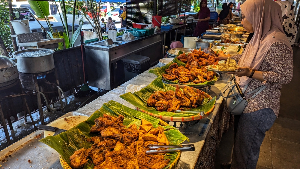 Fried ‘tempeh’, ‘tauhu’ and chicken line the ‘nasi kerabu’ station. — Picture by Ethan Lau