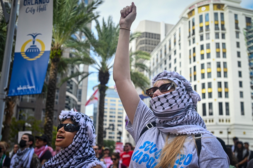 Pro-Palestinian protesters hold signs as people rally in support of Gaza and Lebanon in front of the City Hall to mark one year of the war between Hamas and Israel in Orlanda, Florida, on October 5, 2024. Protesters are ramping up their demonstrations in anticipation of the October 7th one year anniversary of the attack on Israel by Hamas. — AFP pic