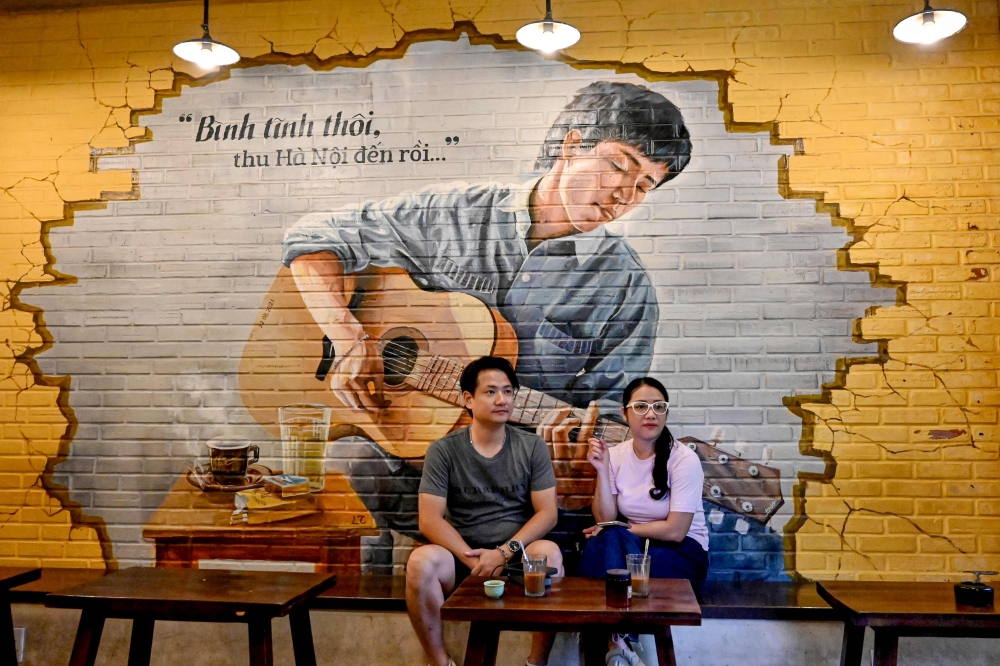 This photo taken on August 21, 2024 shows customers sitting with their coffee at a cafe in Hanoi. — AFP pic