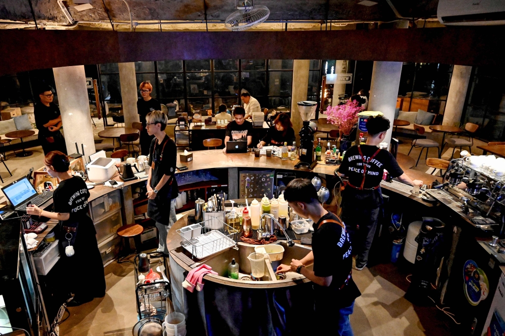 This photo taken on August 21, 2024 shows coffee house employees working at a cafe in Hanoi. — AFP pic