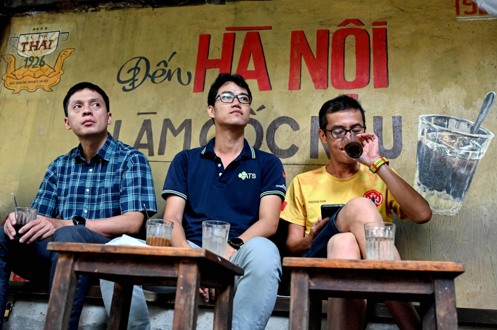 This photo taken on August 21, 2024 shows coffee house customers drinking coffee at a cafe in Hanoi. — AFP pic