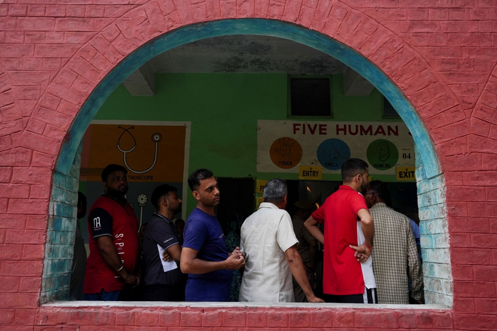 People wait in line outside a polling station to vote during the state assembly elections, in Karnal in the northern state of Haryana, India October 5, 2024. — Reuters pic  