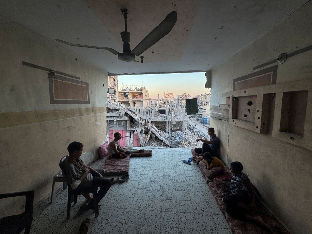 Palestinians rest near rubble of houses destroyed in Israeli strikes, amid the Israel-Hamas conflict, in Khan Younis in the southern Gaza Strip, September 30, 2024. — Reuters pic