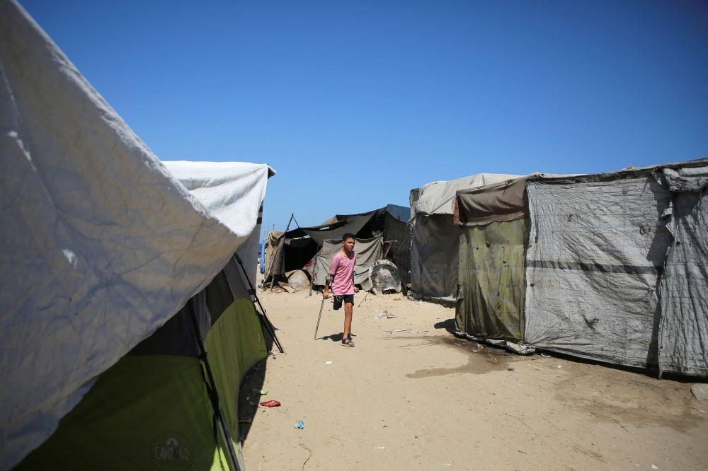 Palestinian Waseem Mohammed, who lost his leg in an Israeli strike, uses crutches as he walks at a tent camp for displaced people, amid the Israel-Hamas conflict, in Khan Younis, in the southern Gaza Strip September 11, 2024. — Reuters pic