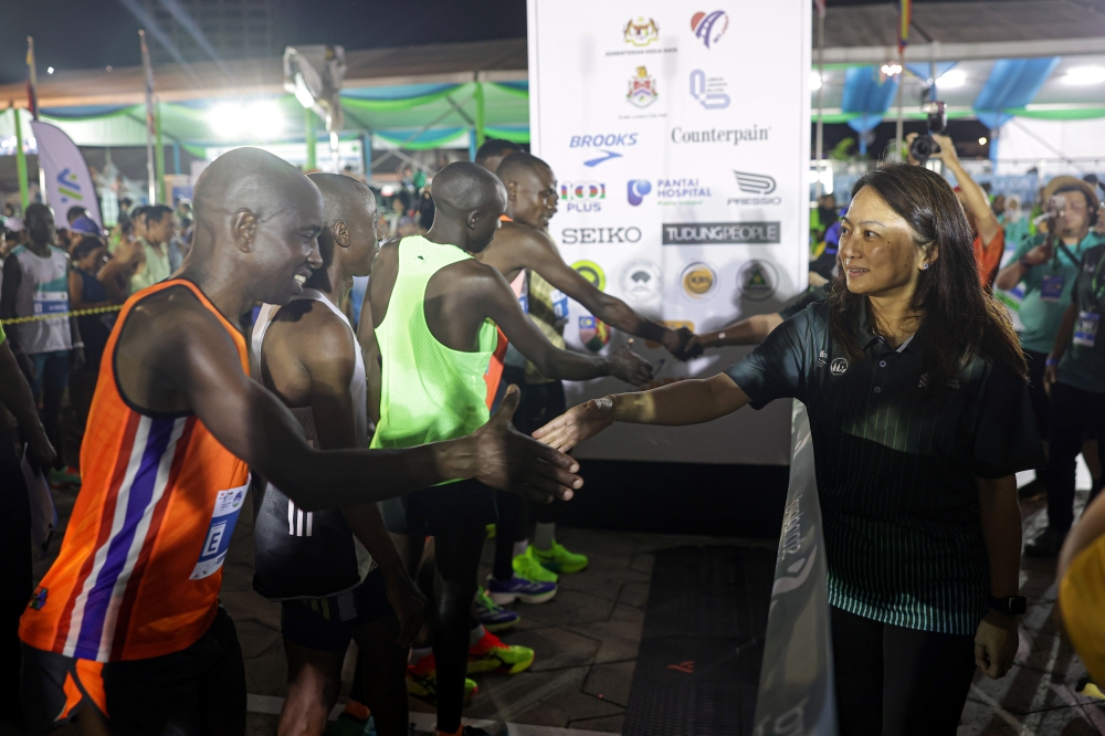 Youth and Sports Minister Hannah Yeoh (right) greets participants before flaging off for the Full Marathon category in conjunction with the Kuala Lumpur Standard Chartered Marathon 2024 running event at Dataran Merdeka October 6, 2024. — Bernama pic