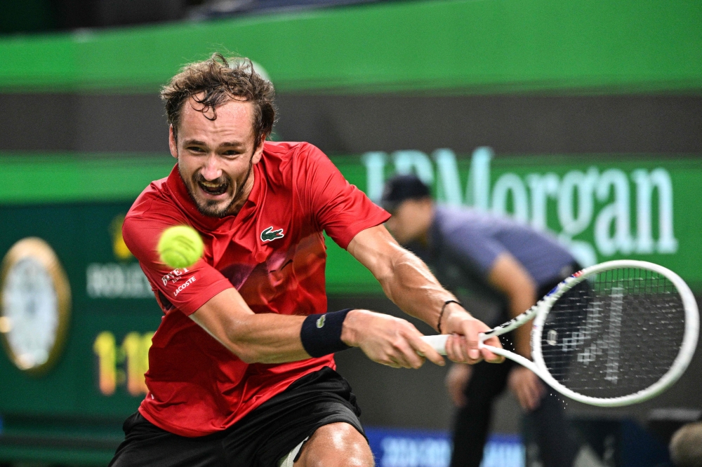 Russia's Daniil Medvedev hits a return to Italy's Matteo Arnaldi during their men's singles match at the Shanghai Masters tennis tournament in Shanghai October 6, 2024. — AFP pic