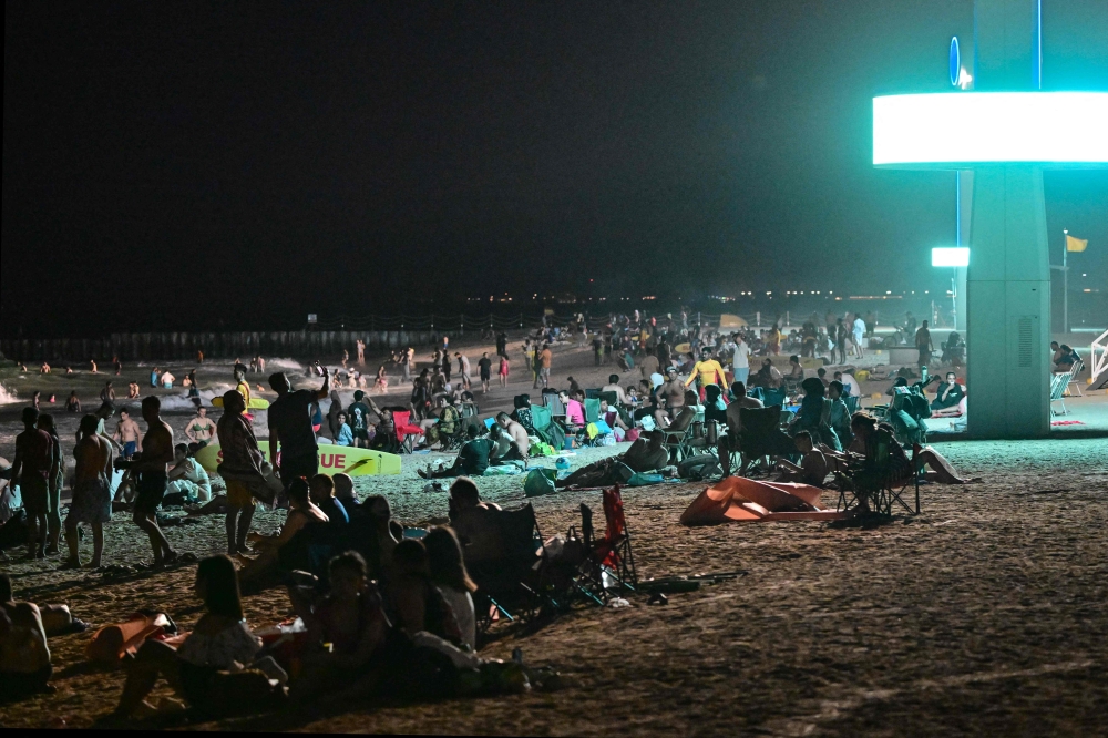 People gather at the Umm Suqeim beach in Dubai during the night of October 5, 2024. — AFP pic