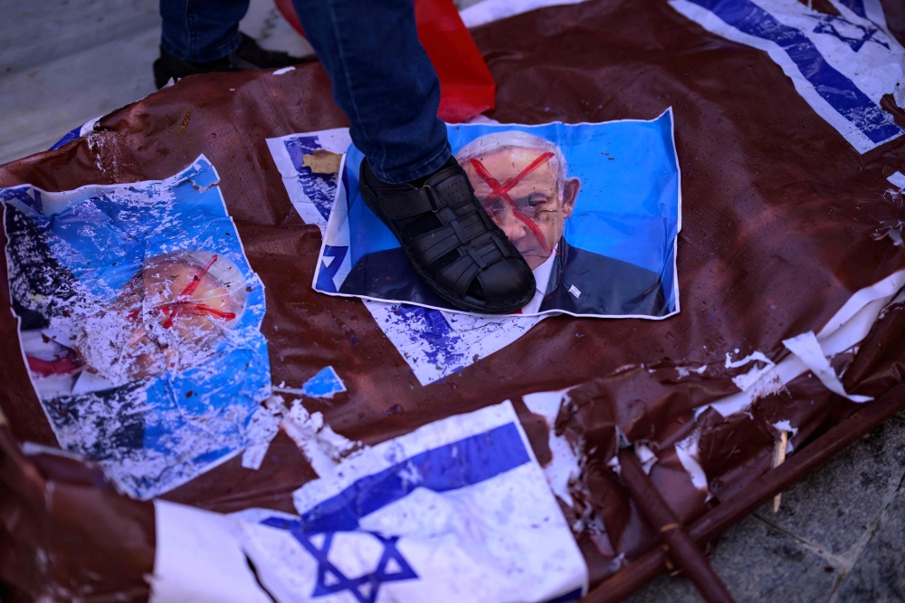 A protester steps on a picture of Israel’s Prime Minister Benjamin Netanyahu during a rally at the Beyazit Square in Istanbul, on October 6, 2024, on the eve of the anniversary of the October 7 Hamas attack. — AFP pic 