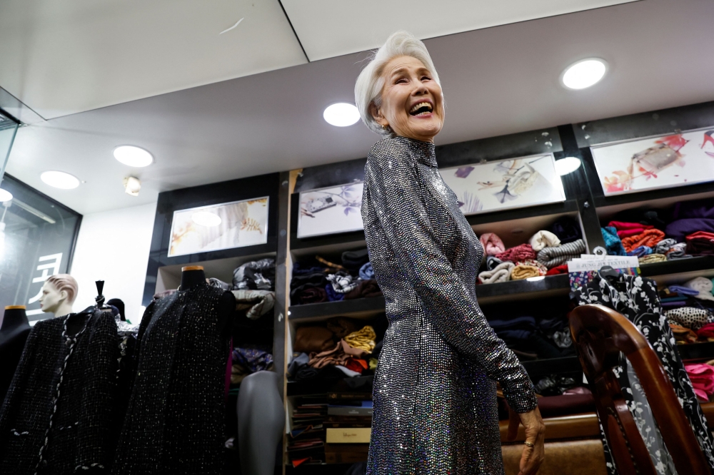 Choi Soon-hwa smiles as she looks at herself after changing into a dress at a tailor shop, in Seoul October 4, 2024. — Reuters pic