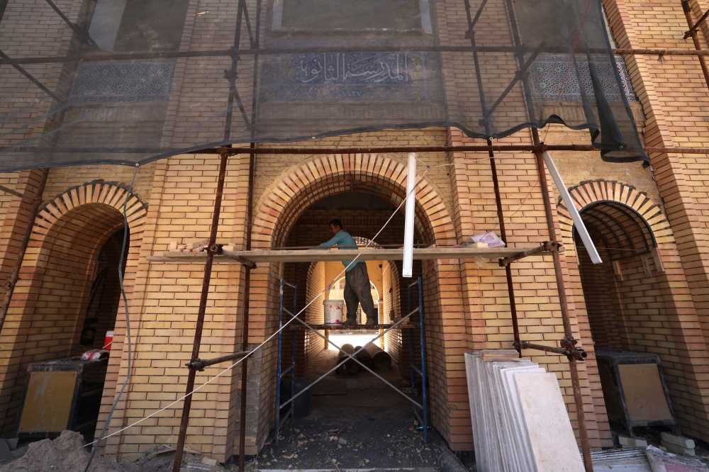 An Iranian worker renovates an old school building on Al-Mutanabbi Street in Al-Saray neighborhood, in Baghdad September 10, 2024.  — AFP pic