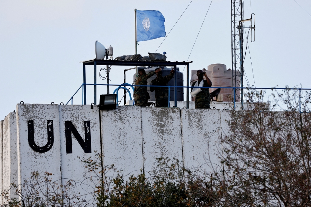 Members of the United Nations peacekeepers (Unifil) look at the Lebanese-Israeli border, as they stand on the roof of a watch tower in the town of Marwahin, in southern Lebanon, October 12, 2023. — Reuters pic  