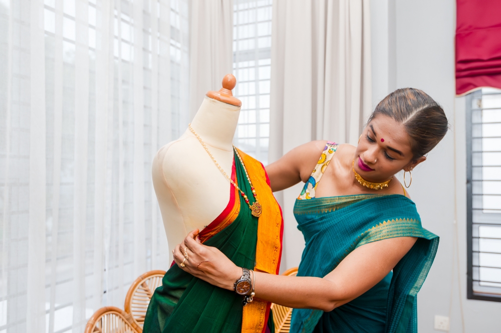 Shamini drapes a safee from her Deepavali collection before a ‘livestream’ advertising session. — Picture by Raymond Manuel 