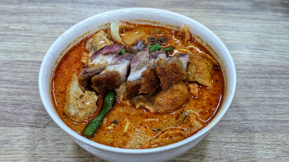 The perfect marriage: crispy, salty ‘siu yuk’ and rich, flavourful ‘curry mee’. — Picture by Ethan Lau