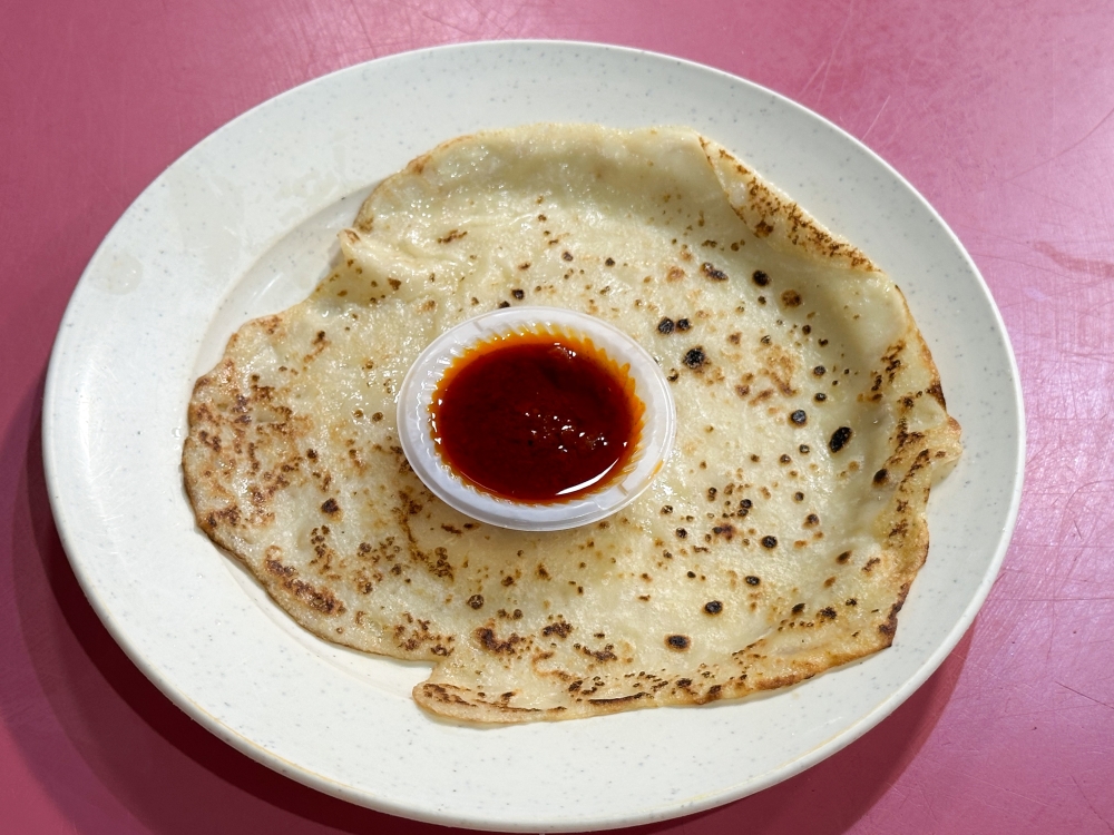 The soft, slightly chewy ‘lempeng kelapa’ is best eaten hot from the griddle with their ‘sambal biasa’ or ‘sambal sardin’. — Picture by Lee Khang Yi