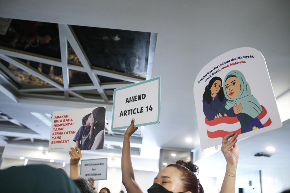 An activist holds up a placard during an event on the country’s citizenship laws in Taman Tun Dr Ismail, Kuala Lumpur, on May 17,2023. — Picture by Ahmad Zamzahuri